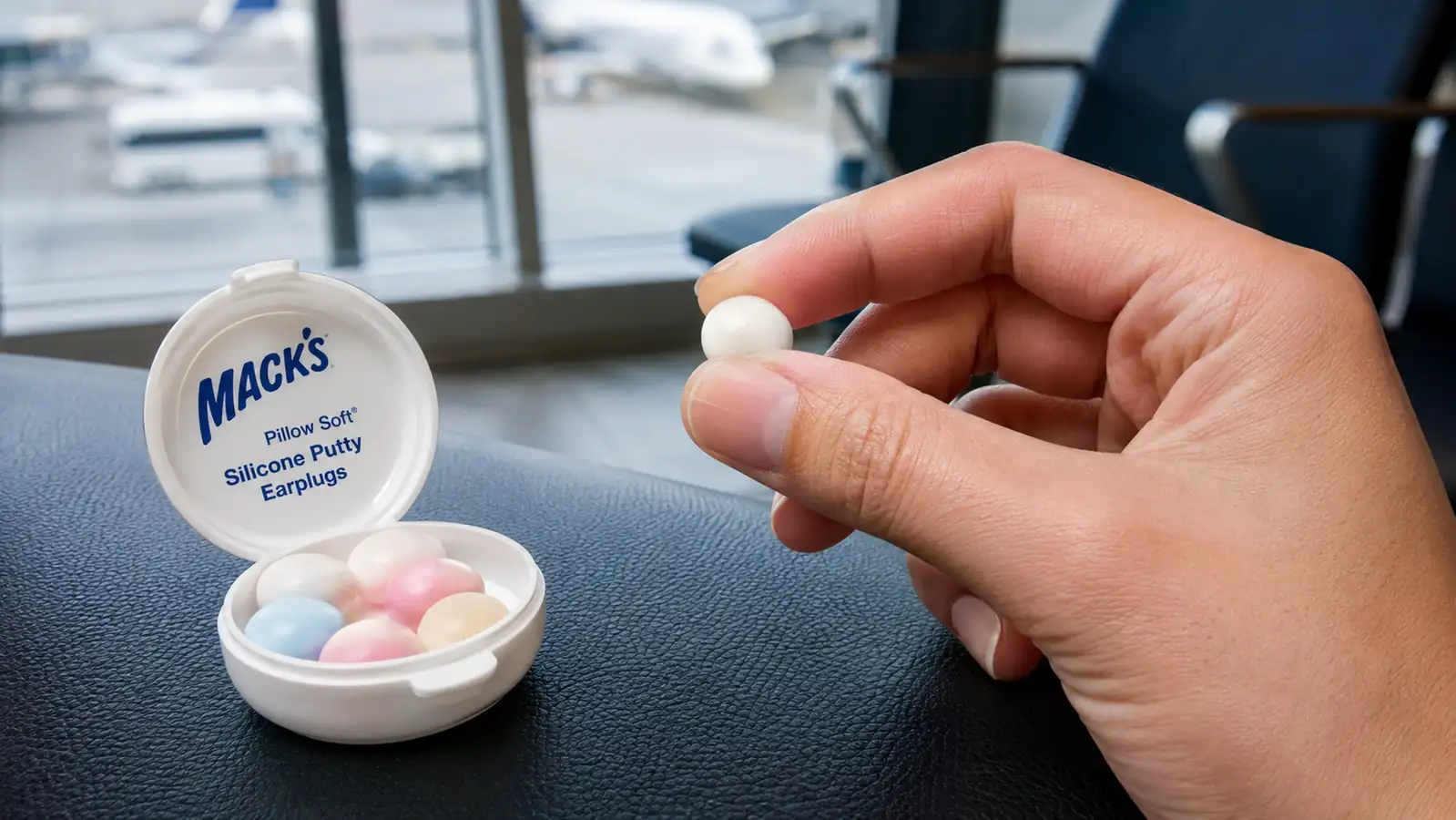 Hand rolling a Mack's Pillow Soft silicone earplug into a small ball before shaping it over the ear