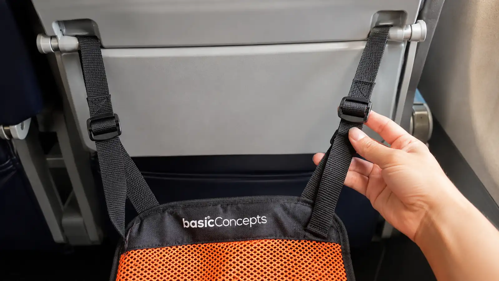 Close-up of the BASIC CONCEPTS foot hammock straps clipped to the tray table arms showing the adjustable buckle